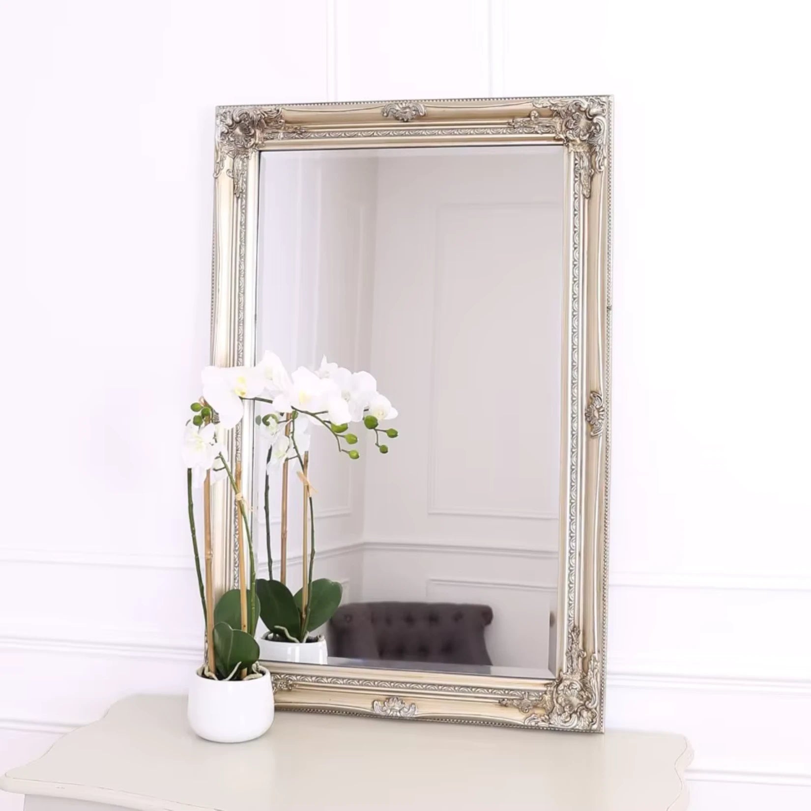 Miroir en bois rectangulaire sur une commande qui reflète des lys.