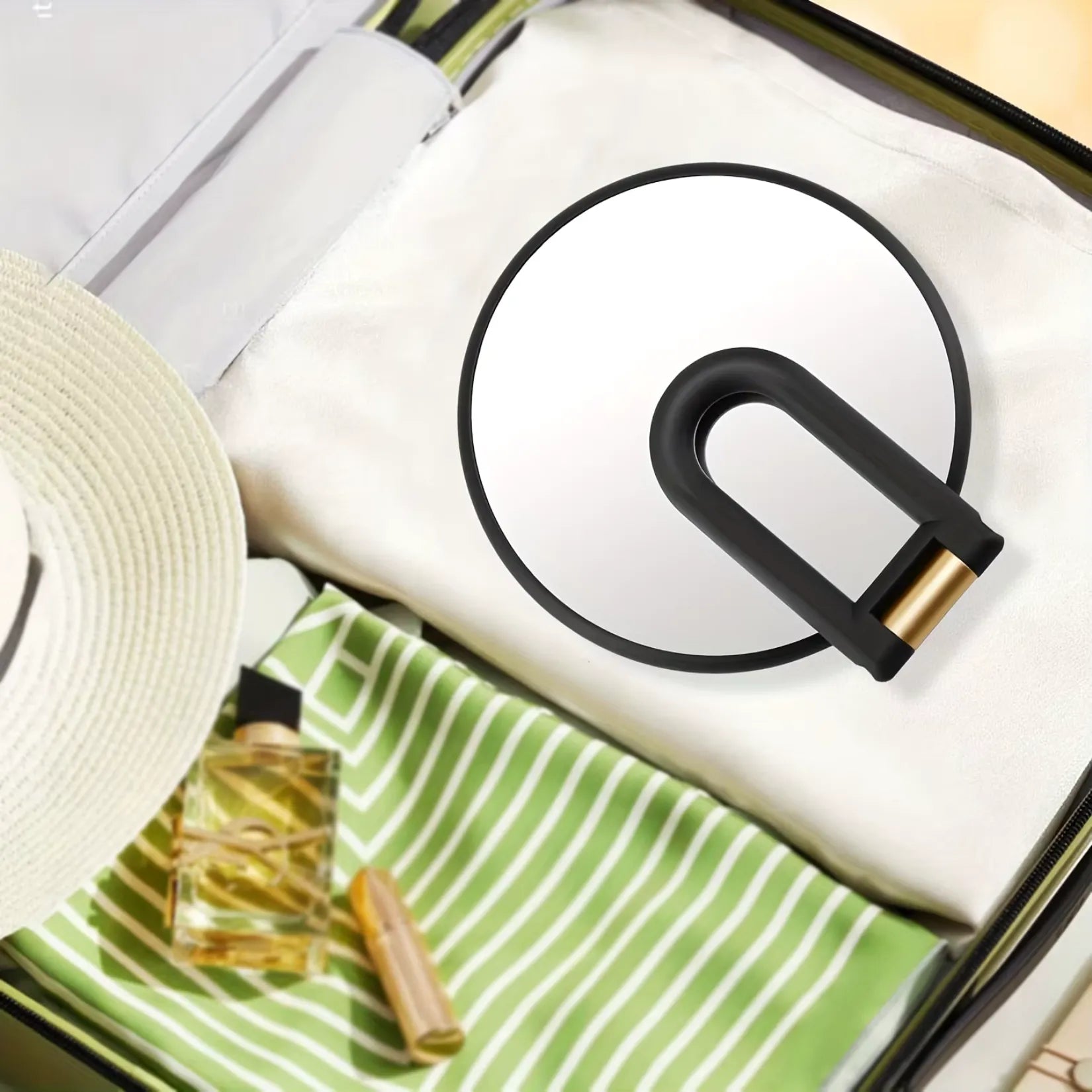 Miroir grossissant x50 replié à plat dans une valise de voyage.