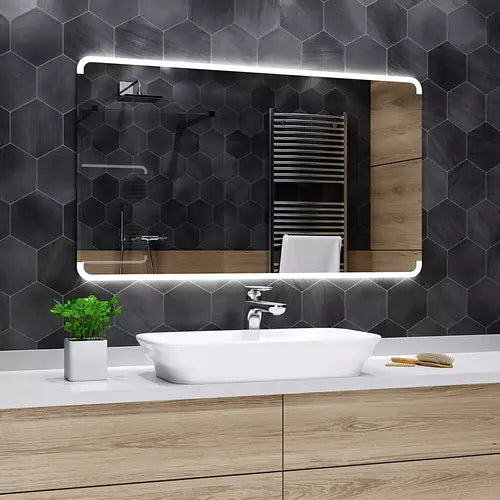 Miroir lumineux 180x80 à LED sur carrelage hexagonal anthracite au-dessus d'une vasque blanche.