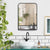 Miroir métal noir mural placé au-dessus d’un lavabo dans une salle de bain végétalisée.