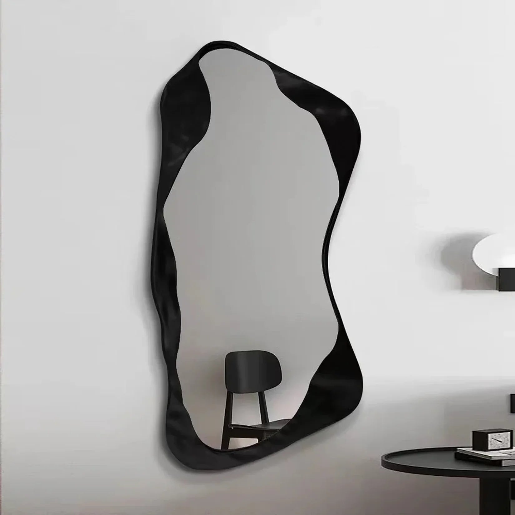 Miroir moderne Aura avec cadre noir sculptural ondulé.
