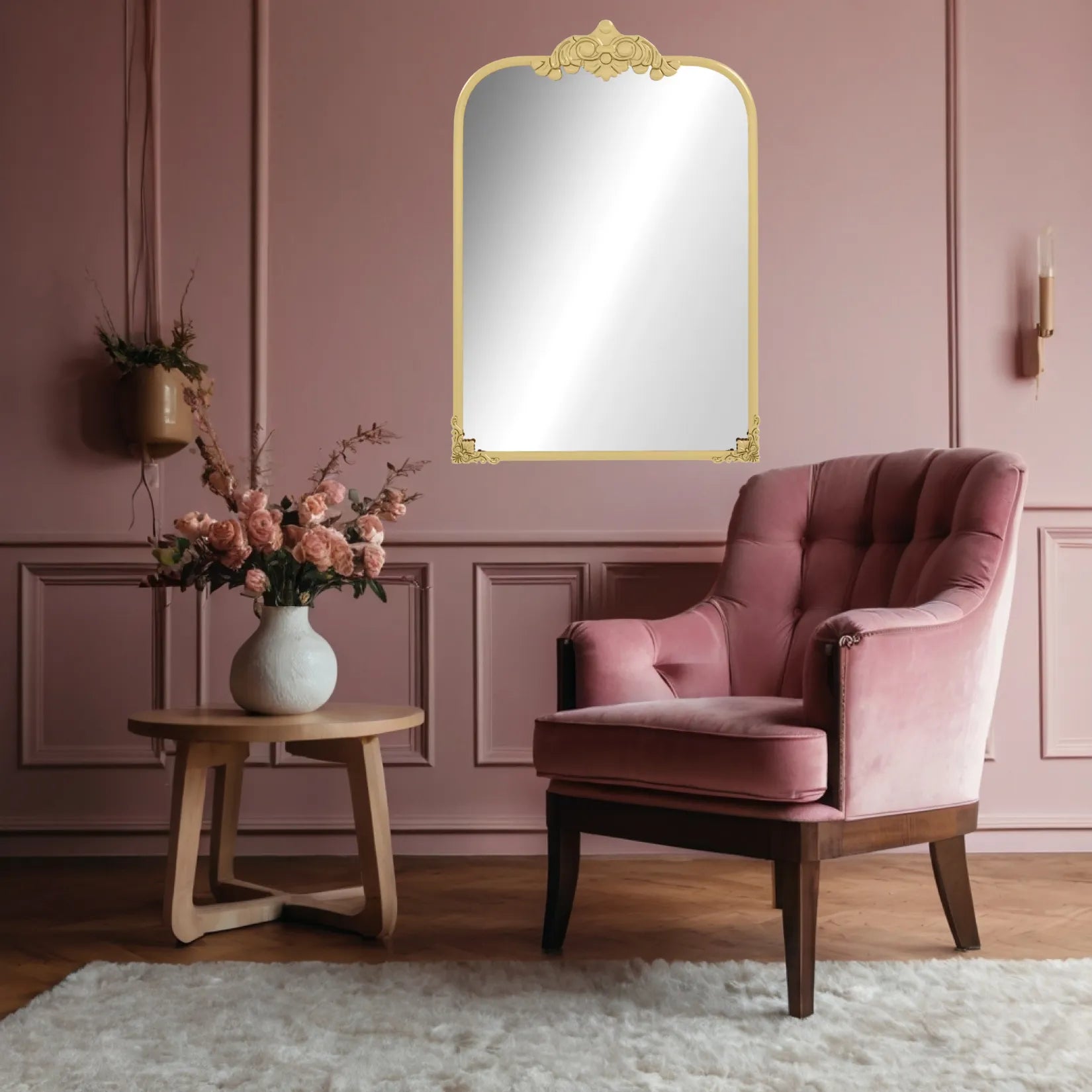 Miroir moulure doré au-dessus d’un fauteuil rose dans une pièce aux tons doux.