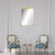 Miroir moulure doré sur mur mouluré blanc entre deux fauteuils Louis XV.