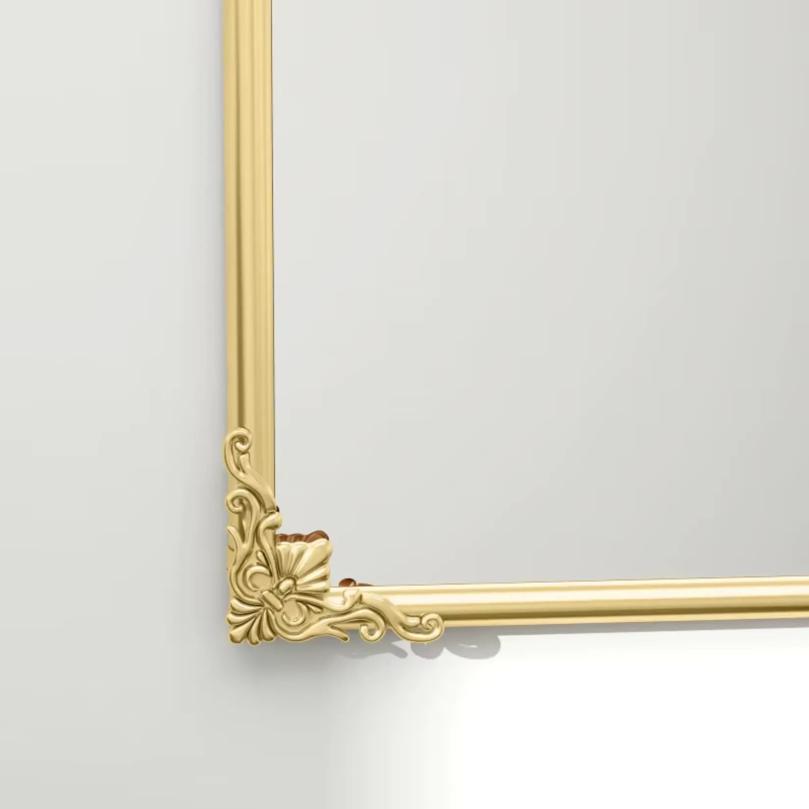 Détail du motif floral en bas du miroir moulure doré avec finition métal laqué.