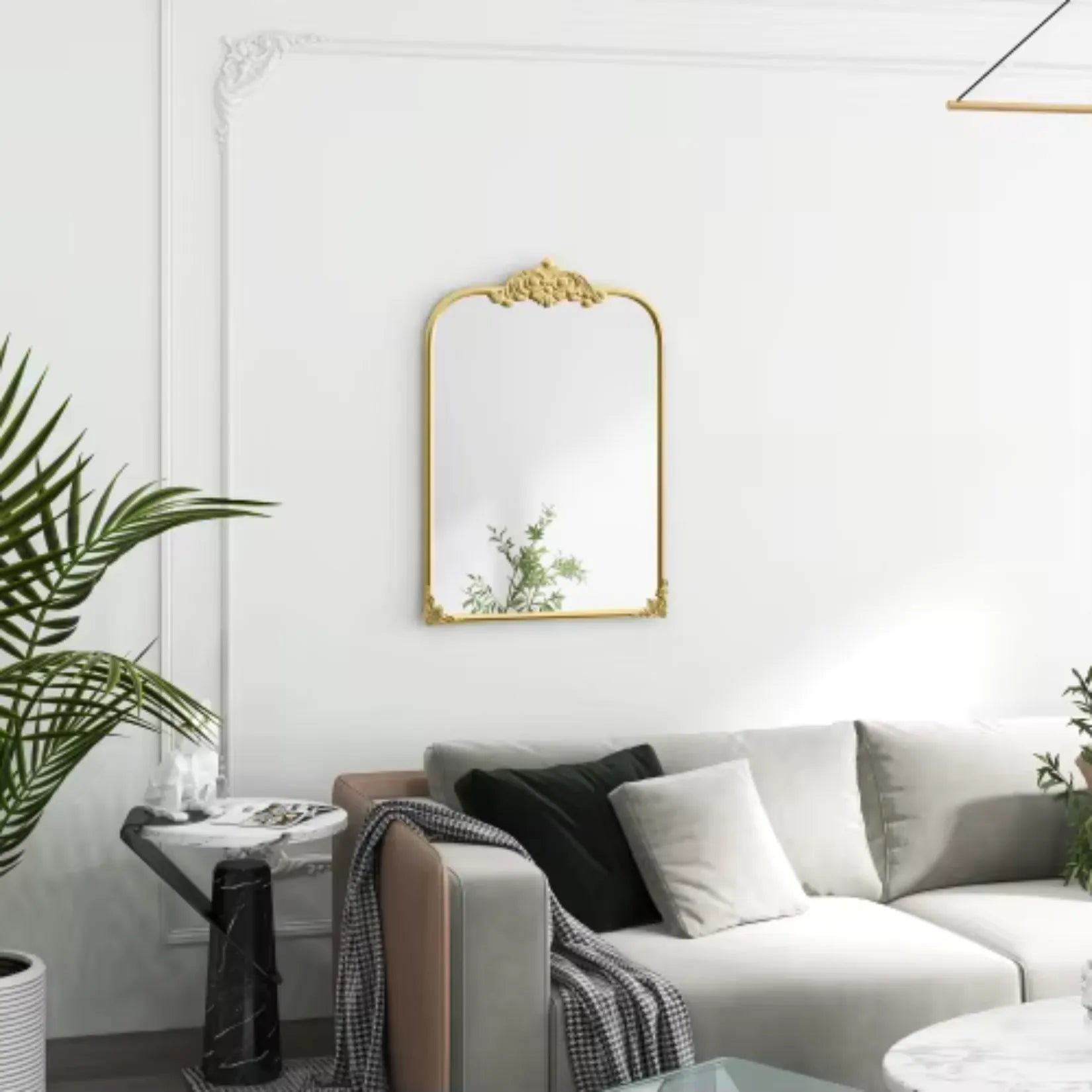 Miroir moulure doré mural dans un salon contemporain blanc et vert.