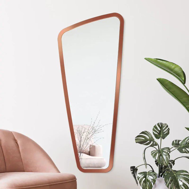 Miroir mural design grande taille avec cadre cuivré installé dans un salon.