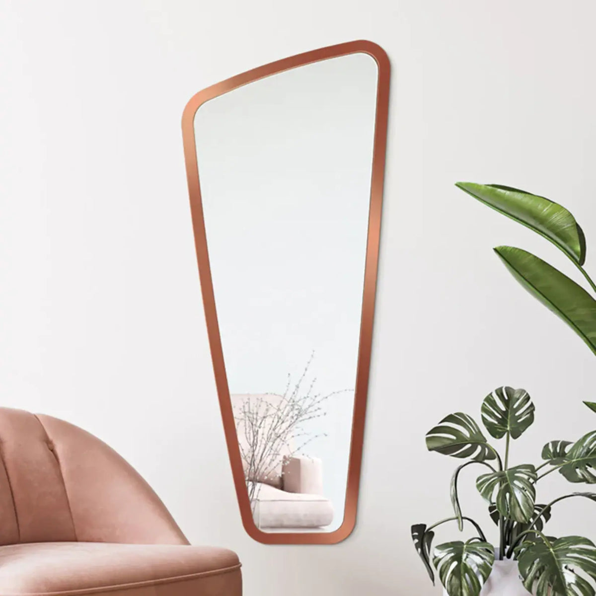 Miroir mural design grande taille avec cadre cuivré installé dans un salon.
