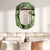 Miroir mural design italien vert au-dessus d’un lit dans une chambre contemporaine.