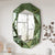 Miroir mural design italien vert au-dessus d’un lit dans une chambre contemporaine.
