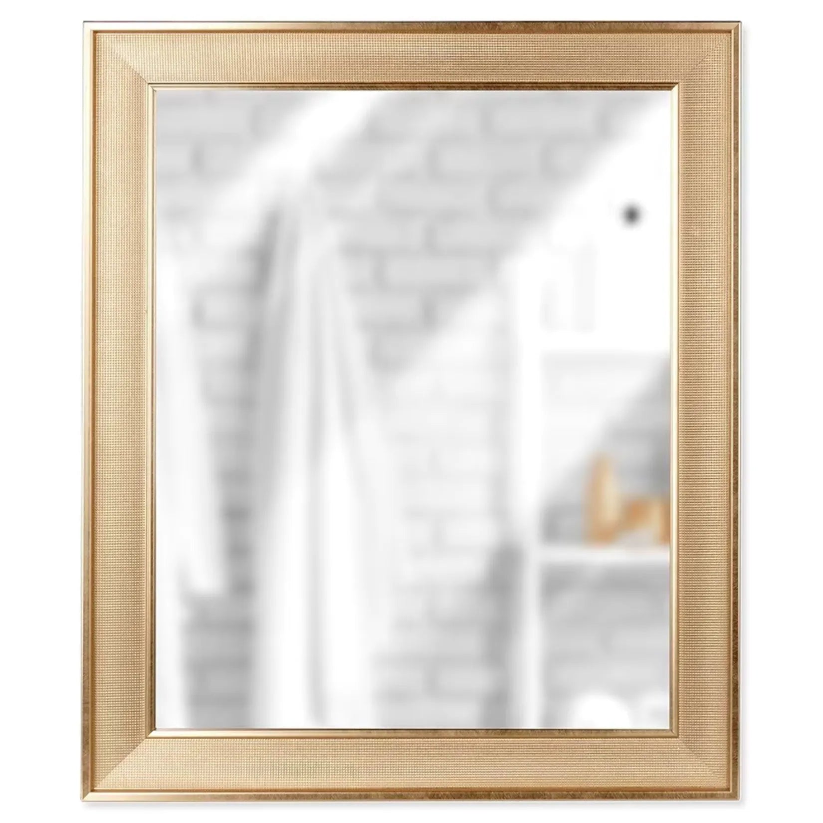 Miroir mural doré montrant un reflet flou sur fond de mur en briques.