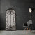 Miroir noir rectangulaire au design fer forgé sur mur noir mat moderne.