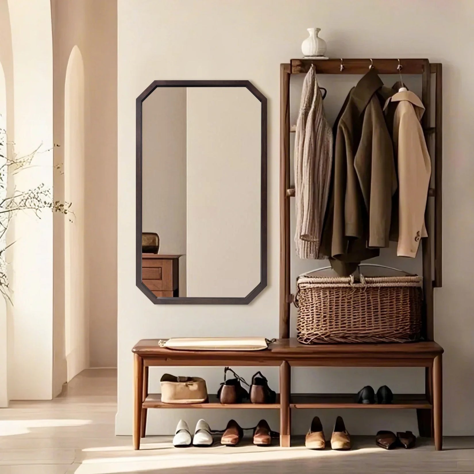 Miroir octogonal en bois dans une entrée avec porte-manteau et banc en bois naturel.