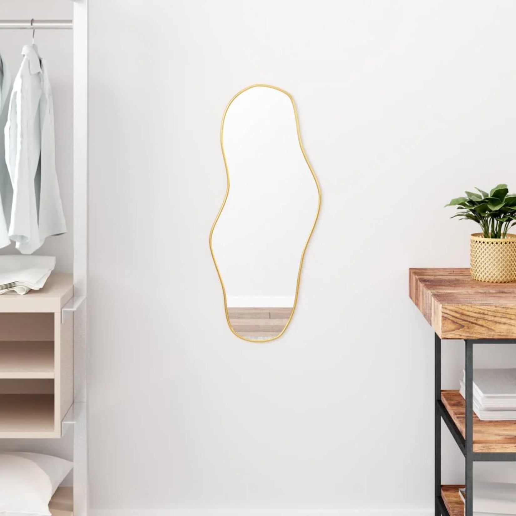 Miroir organique doré installé dans une entrée moderne.