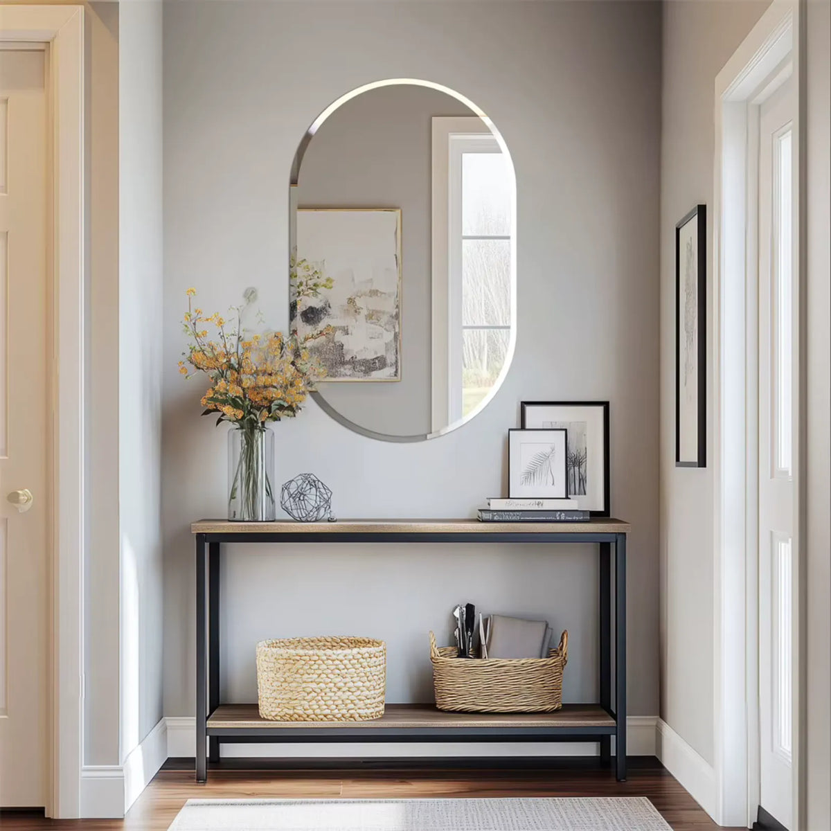 Miroir ovale dans une entrée, au-dessus d'une console en bois.