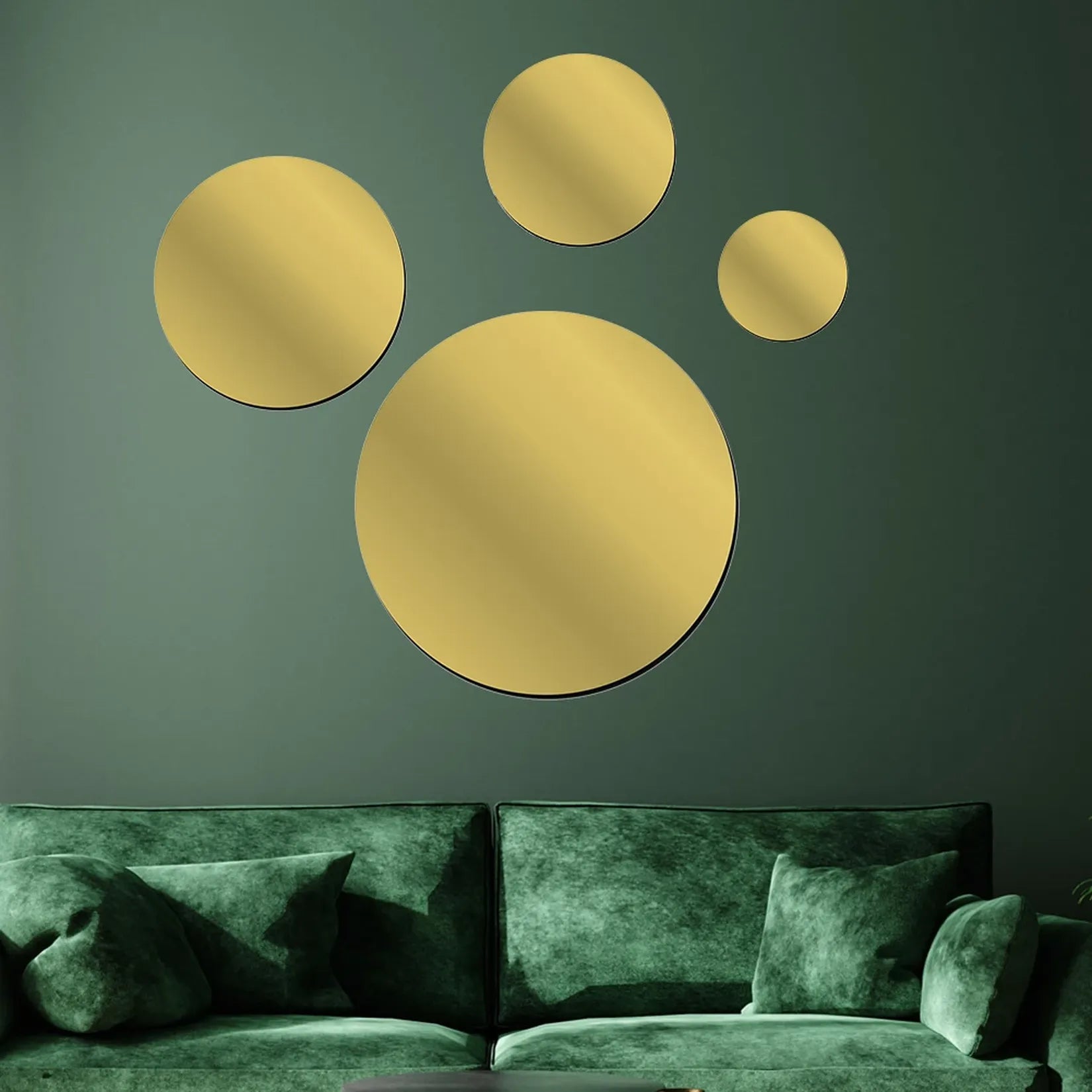 Miroir adhésif rond doré en grappe murale décorative au-dessus d'un canapé vert.