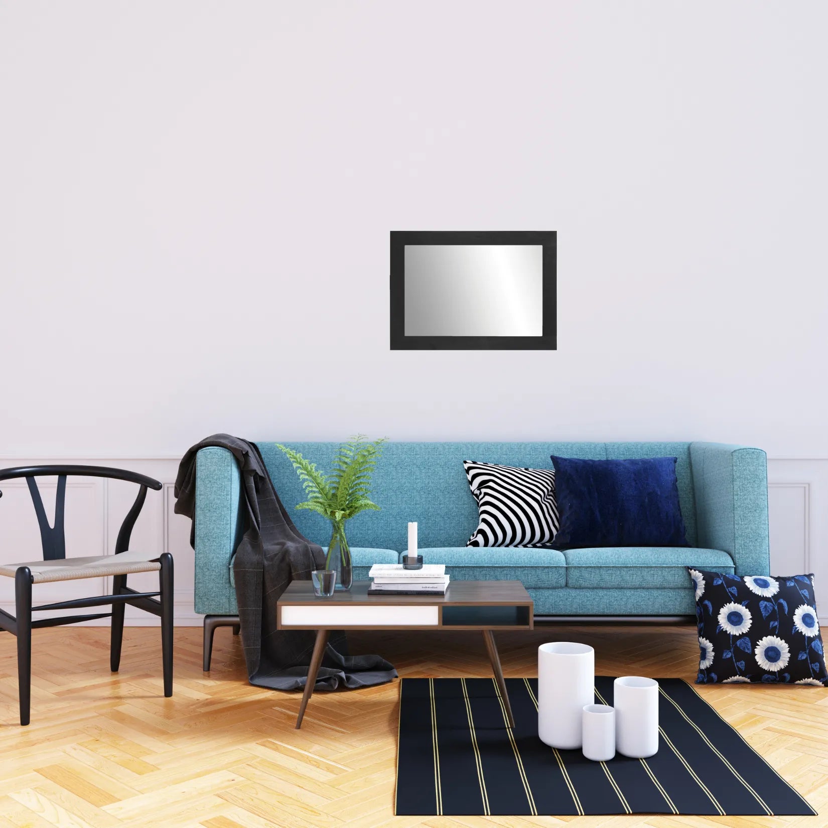 Miroir rectangulaire noir au-dessus d’un canapé bleu dans un intérieur contemporain.