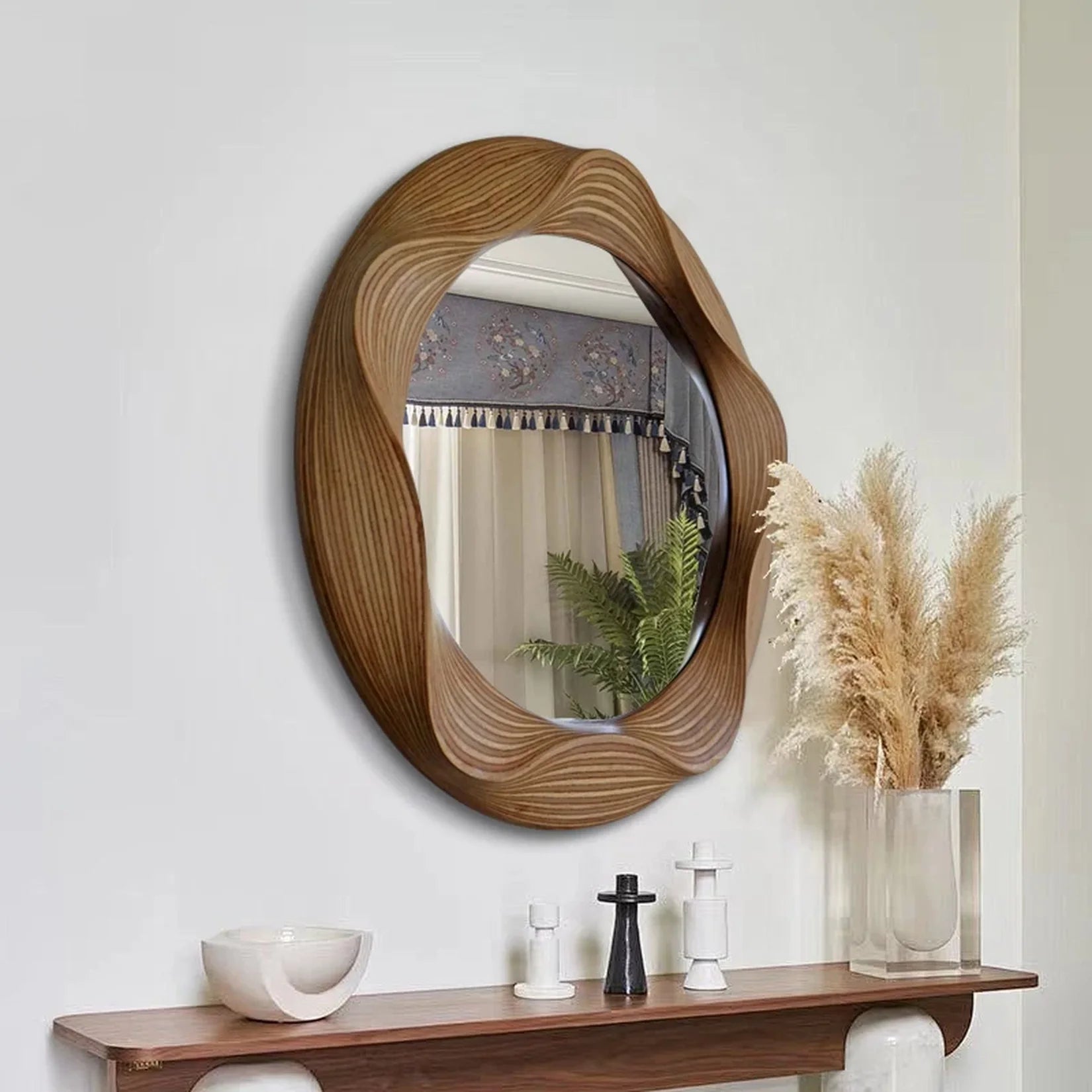 Miroir rond bois sculpté cadre ondulé dans une entrée.