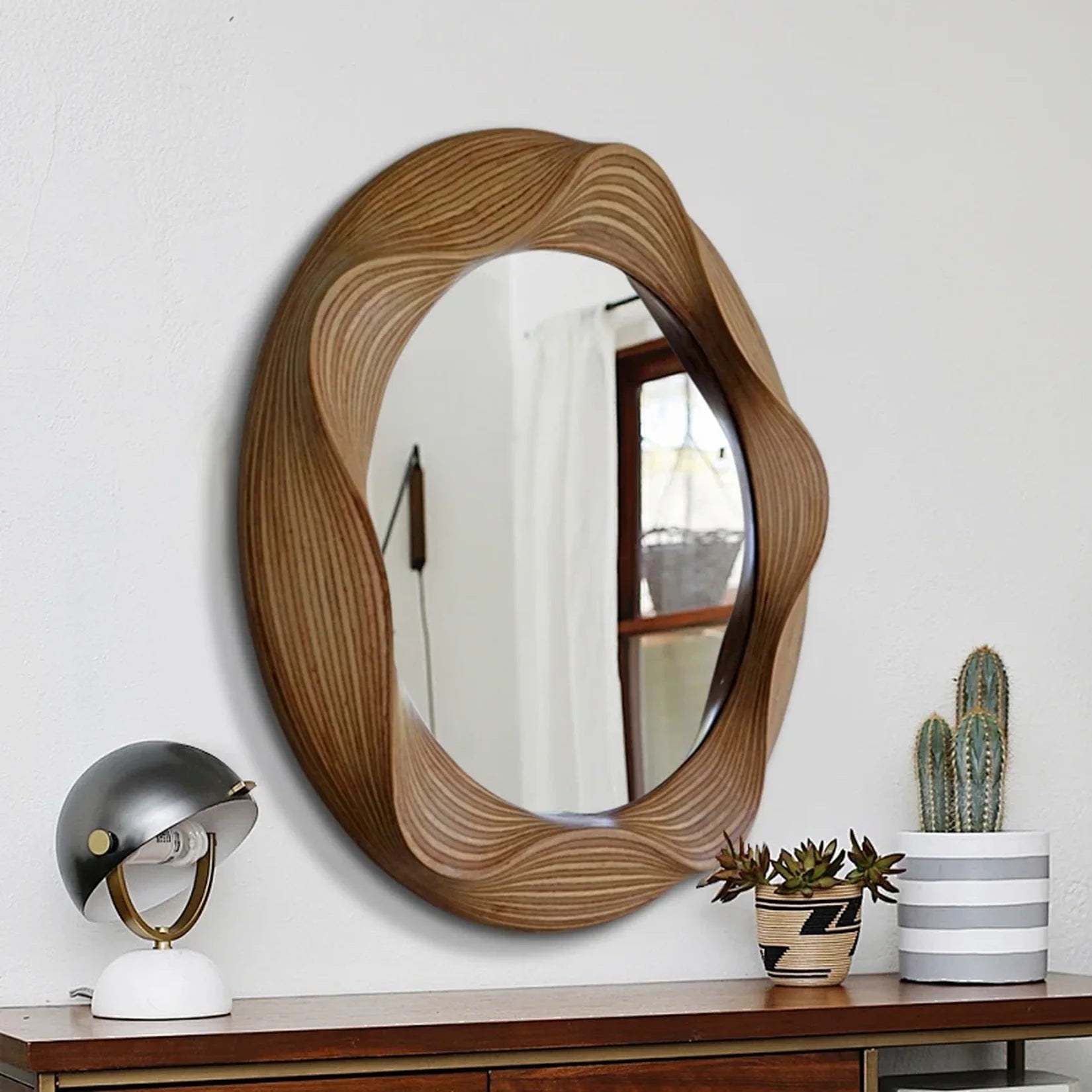Miroir rond bois sculpté au-dessus d'une console déco.
