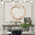 Miroir rond doré 60 cm accroché au mur au-dessus d’une cheminée blanche en marbre.