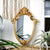 Miroir rond doré baroque posé au sol dans un design bohème.