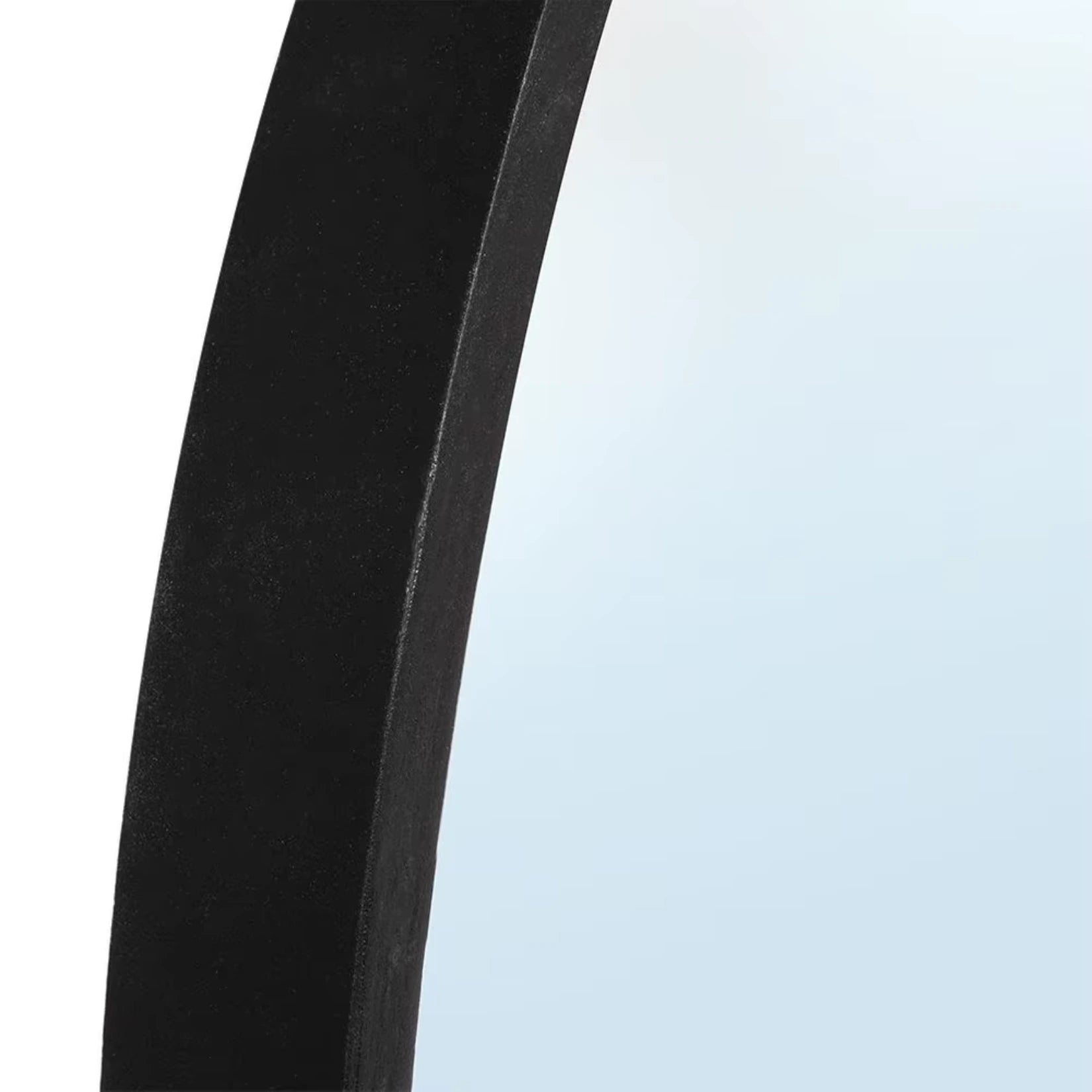 Vue rapprochée du cadre en bois noir du miroir rond, mettant en avant la qualité de fabrication et la texture du matériau.