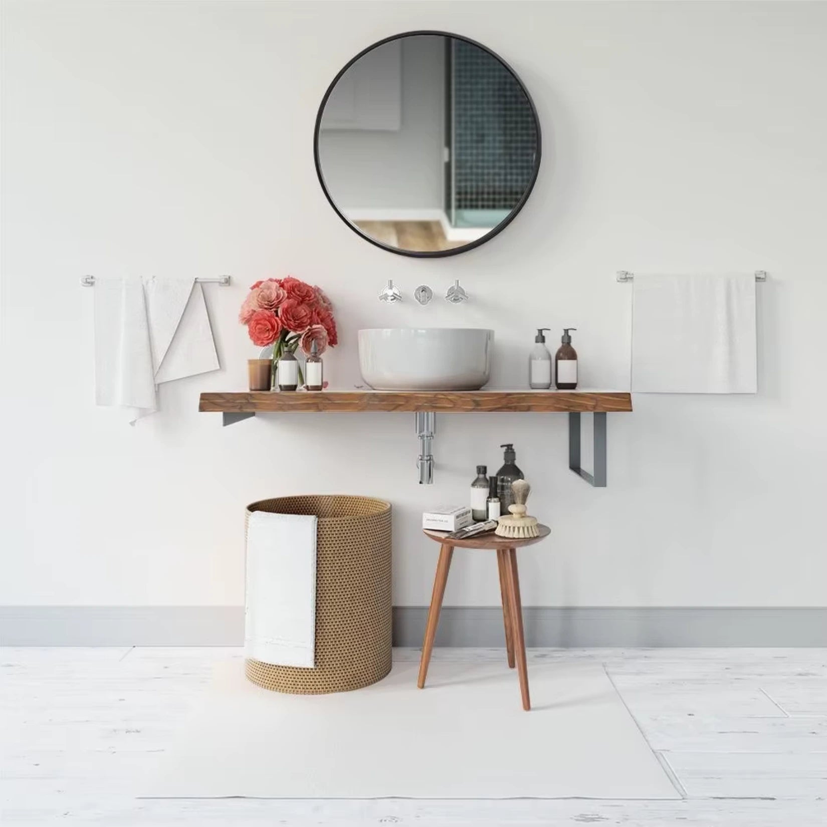 Miroir rond noir installé dans une salle de bain moderne avec une vasque suspendue et des accessoires décoratifs.