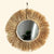 Miroir rond en raphia avec perles en bois, un artisanat fait main.