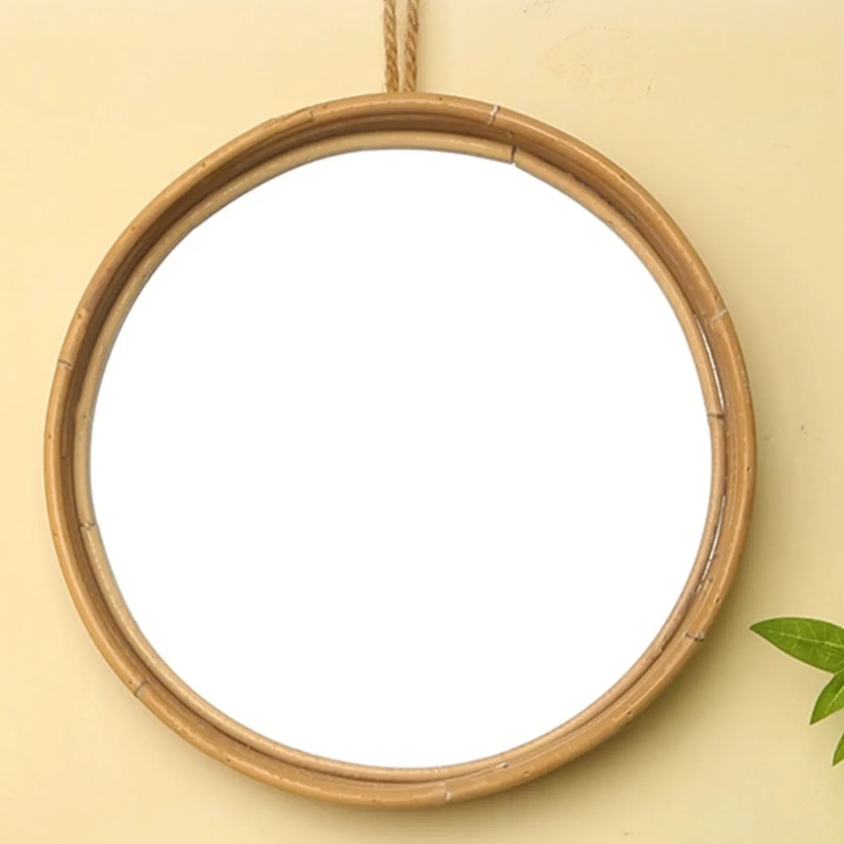 Miroir rond rotin accroché au mur vue de face.