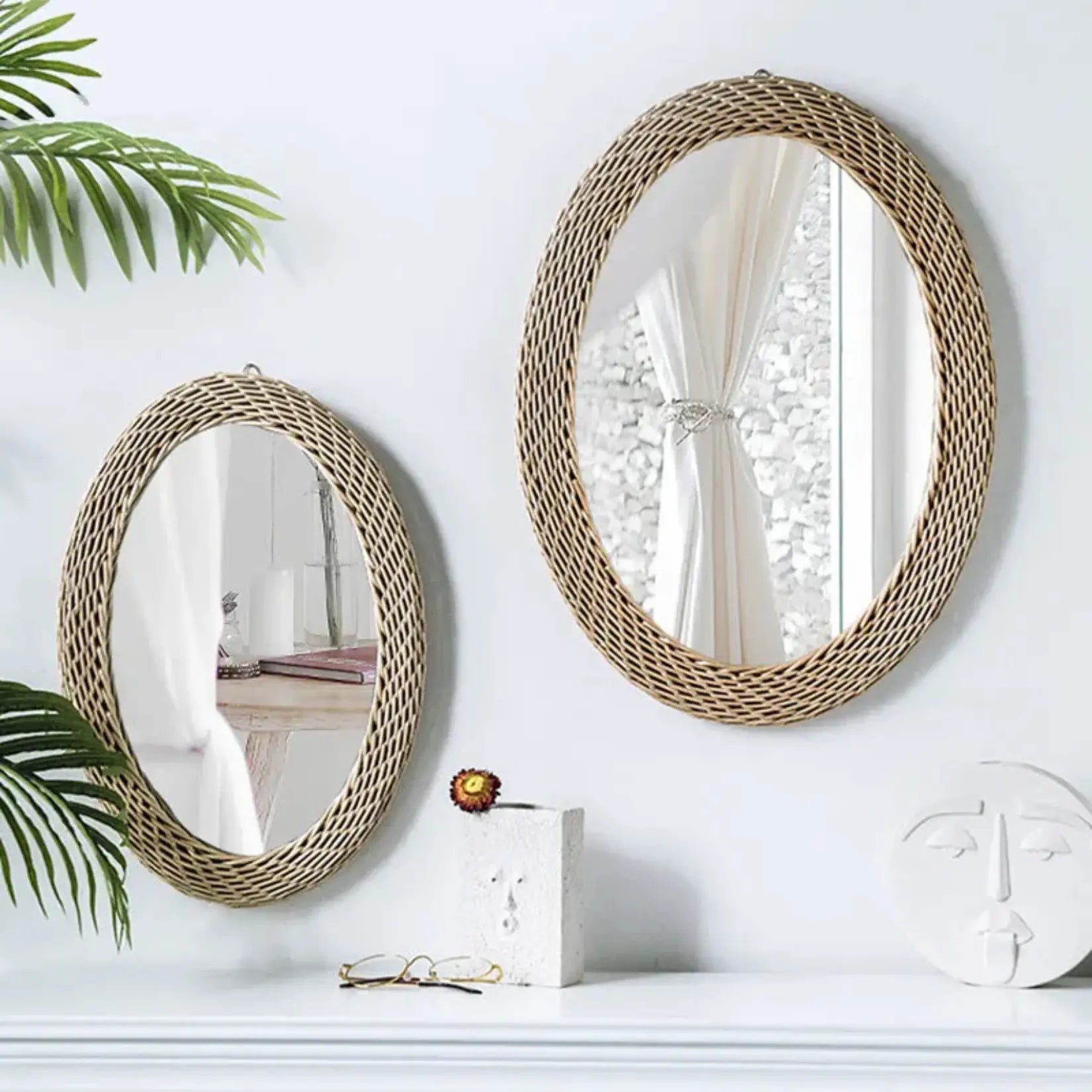 Deux Miroirs Rotin Ovale accrochés au mur blanc au-dessus d’un meuble avec décoration naturelle.