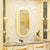 Miroir salle de bain ovale doré dans une décoration luxueuse.