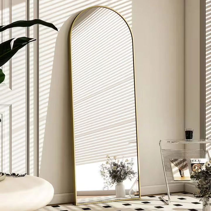Miroir sur pied arrondi pour agrandir visuellement l’espace.
