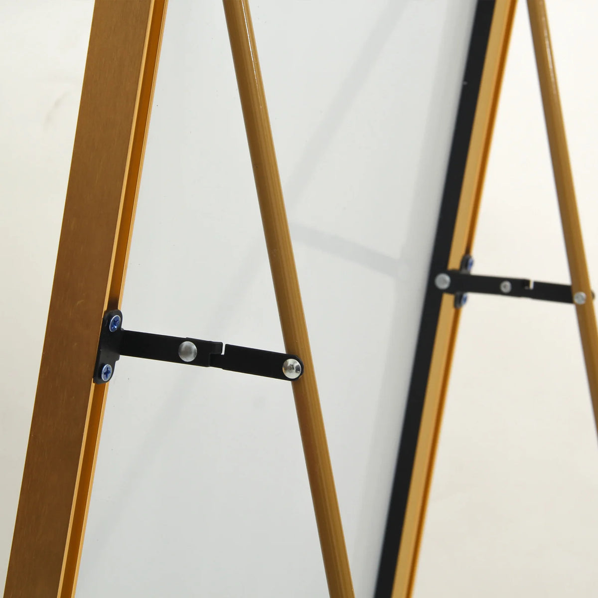 Détail du système rabattable du miroir sur pied doré, assurant stabilité et facilité de rangement.