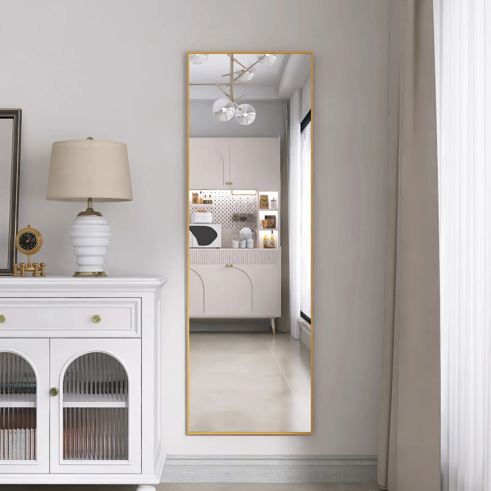 Miroir sur pied doré accroché dans une salle à manger lumineuse et contemporaine.