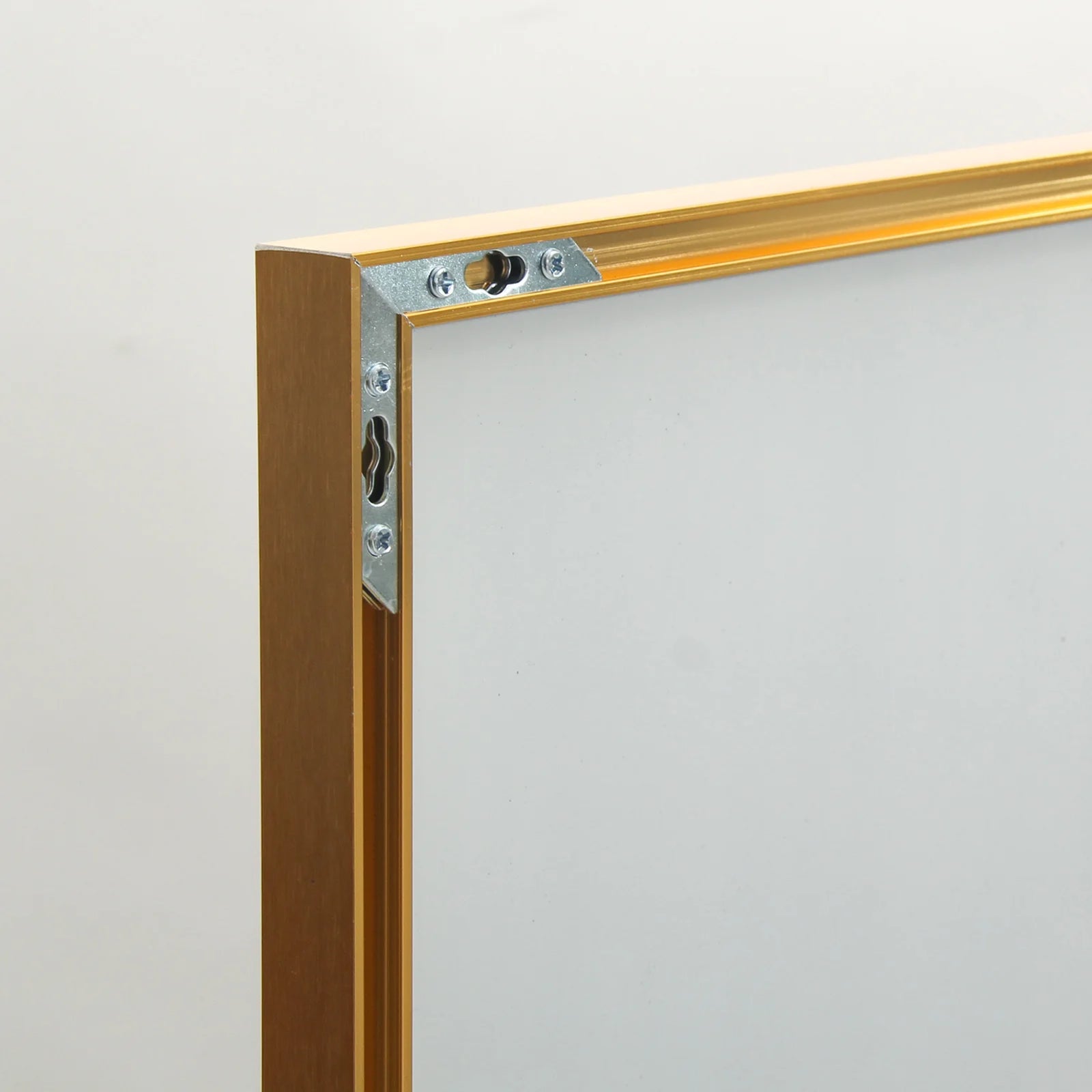 Zoom sur la fixation murale renforcée du miroir sur pied doré pour une installation solide.