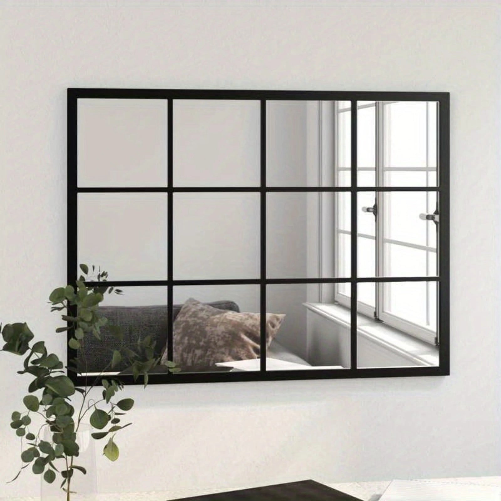 Miroir verrière industriel installé au mur, reflétant une fenêtre et un canapé cosy.