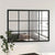 Miroir verrière industriel installé au mur, reflétant une fenêtre et un canapé cosy.