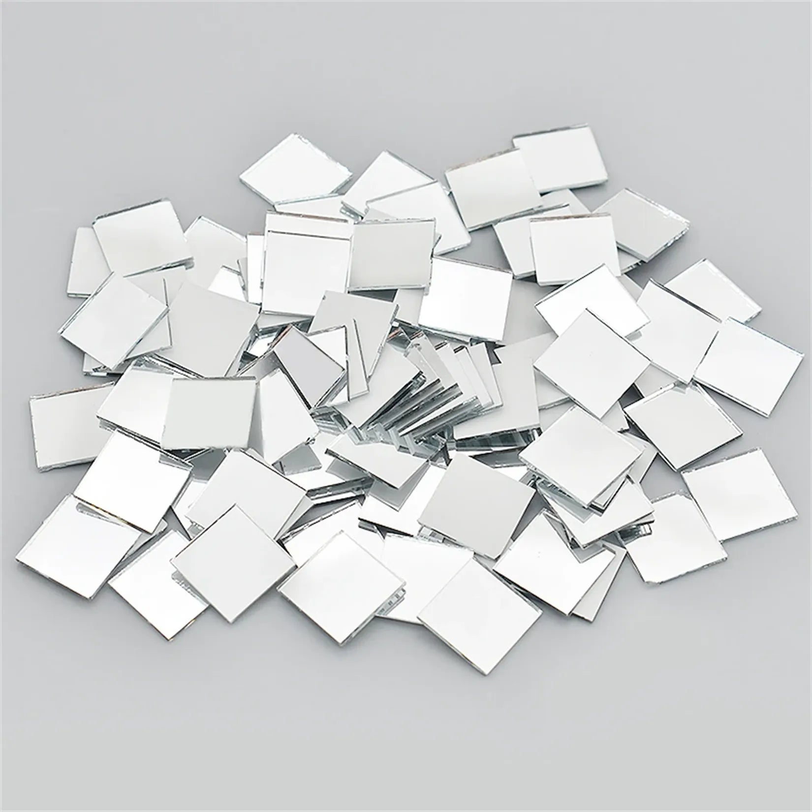 100 carreaux mosaïque miroir verre argent 10x10 mm dispersés fond gris.