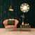 Petit miroir doré rond dans un salon au style art déco avec fauteuil rose et mur graphique vert.